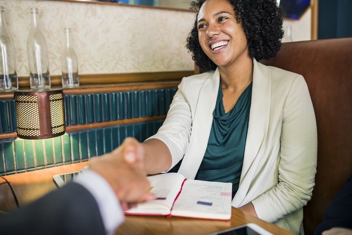 A smiling woman shaking hands with a man