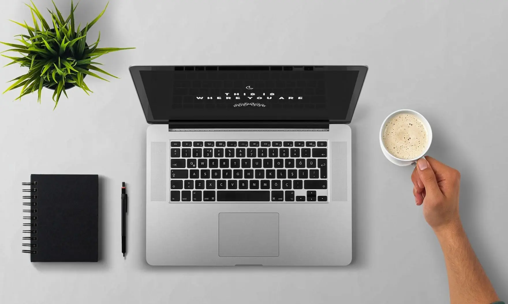 Top view of a laptop, notebook, and a cup of coffee