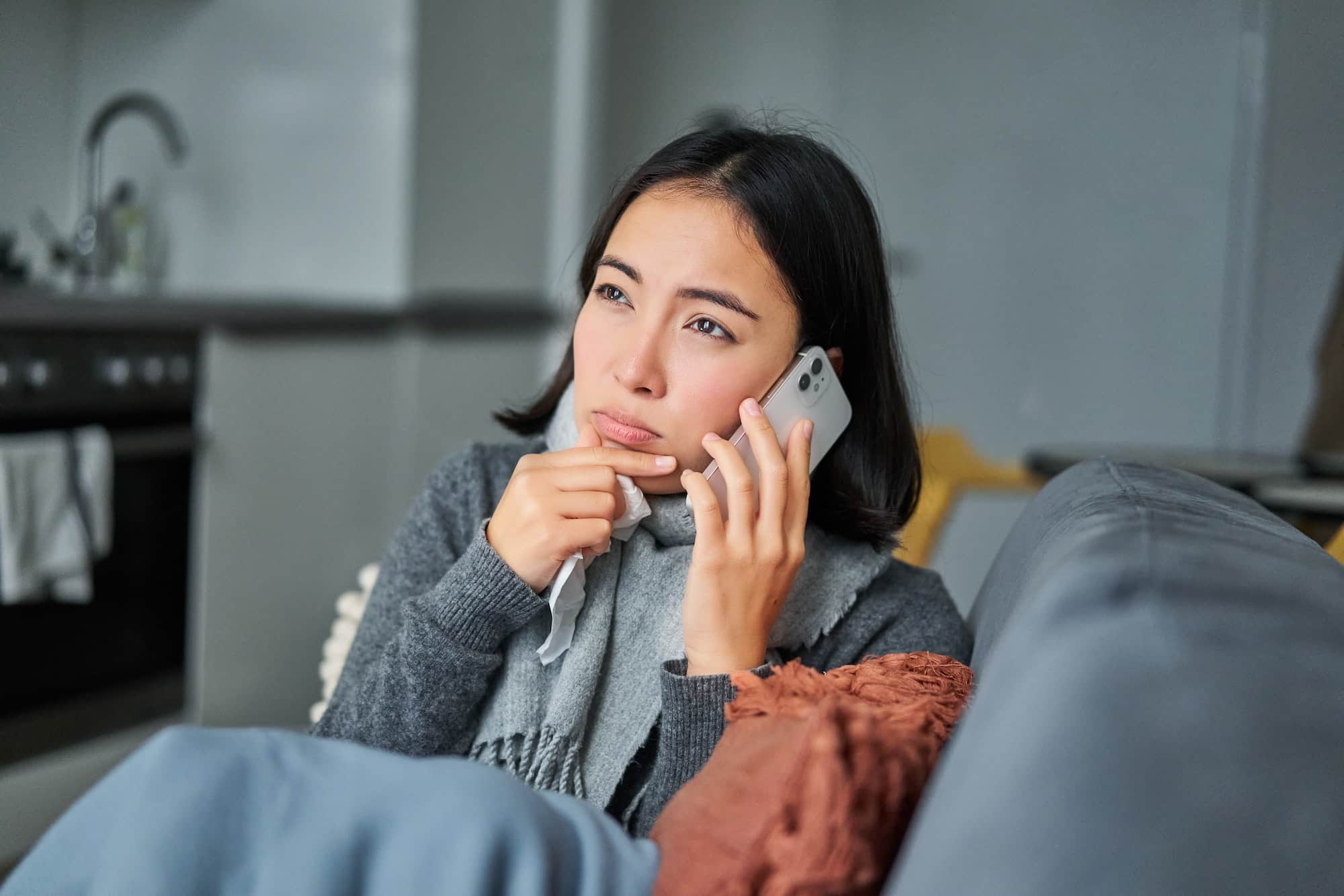 Portrait of sick woman calling her medical clinic, phone call appointment with GP, caught cold and