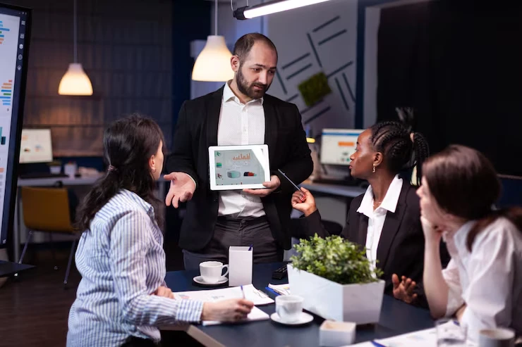 Business executive presenting exclusive territory lead distribution strategy on tablet to professional team