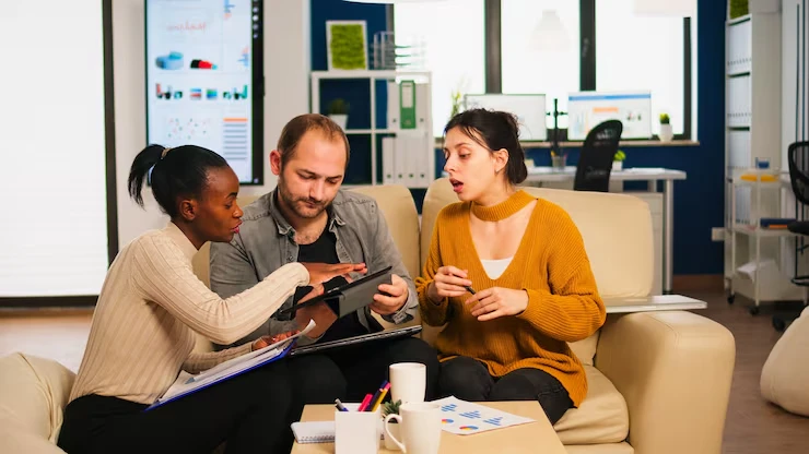 Professional team discussing cold email outreach compliance strategies with documents and tablet in office