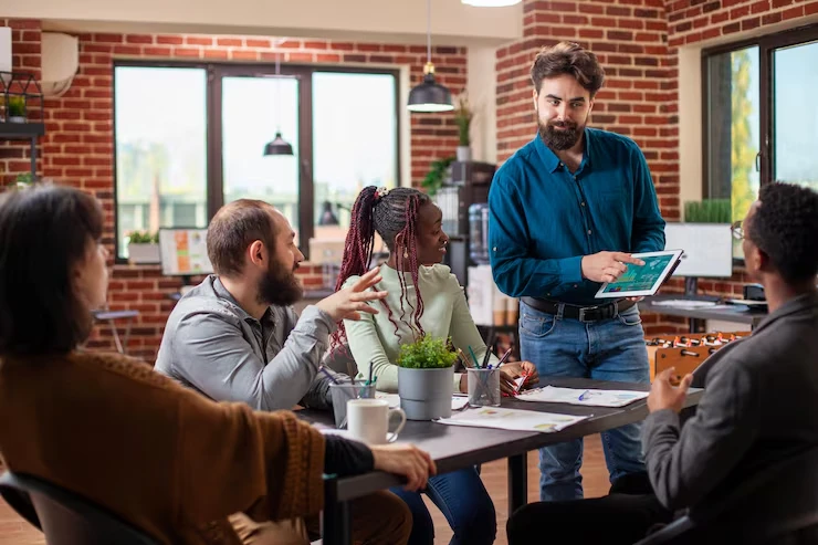 Business team discussing customized investor database development with tablet in modern brick office