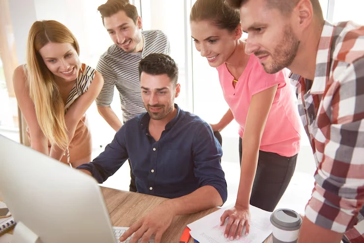 Inbound lead response management team collaborating around computer monitoring real-time lead notifications