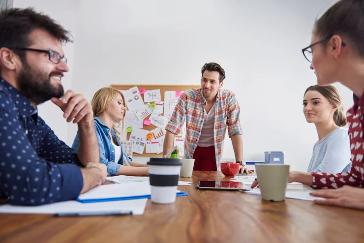 Five professionals in creative meeting discussing payday loan refinance lead strategies with charts