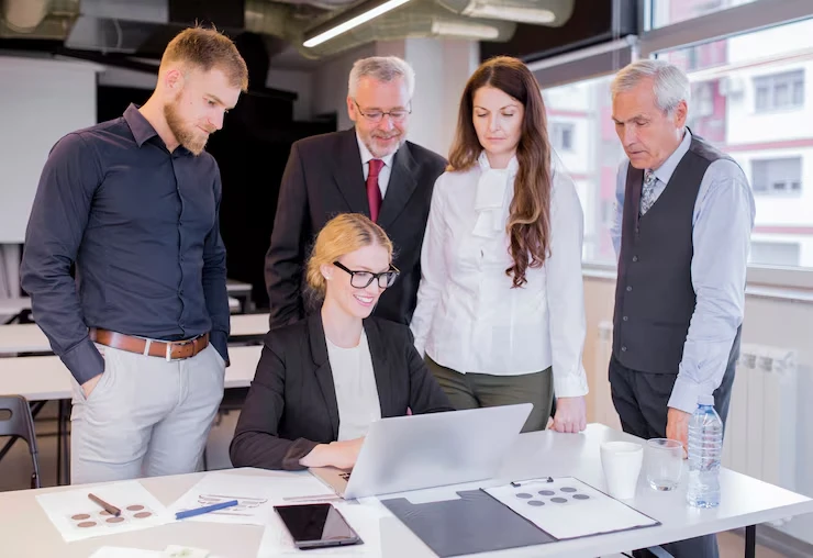Professional team reviewing retargeting campaign data for missed leads recovery on laptop in office meeting
