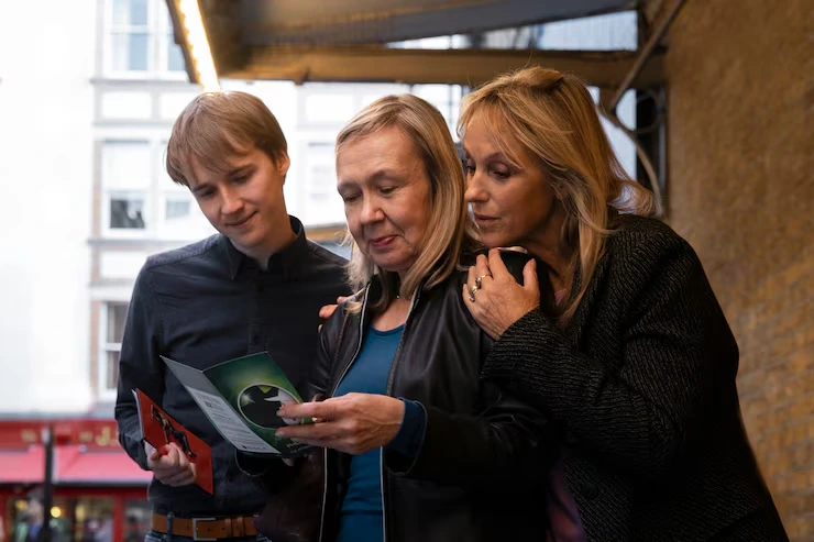 Three business professionals networking and reviewing LinkedIn connection strategies using mobile device