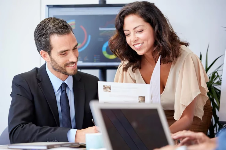 Business consultant and client are reviewing cold email campaign strategies on laptop with analytics dashboard visible