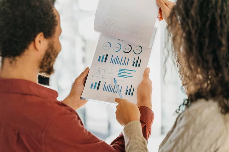 Two analysts examining email campaign performance charts showing engagement metrics and conversion data
