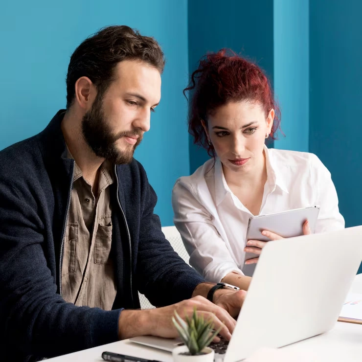 CRO specialist and client analyze conversion funnel data and user behavior metrics on laptop and tablet