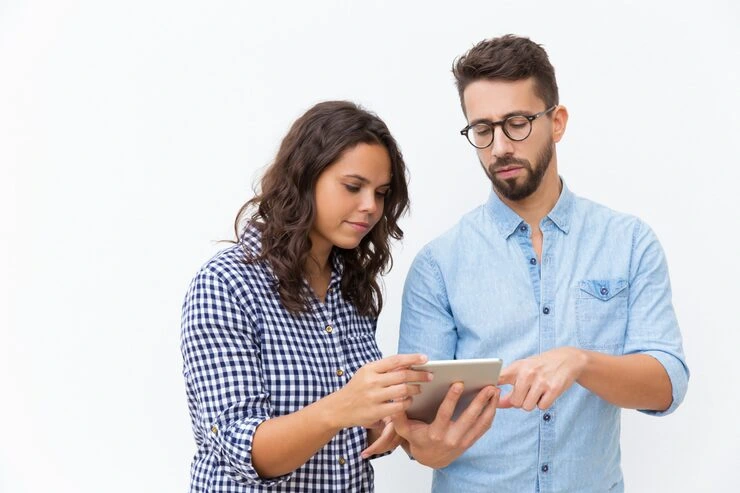 Two researchers analyzing customer demographic data on tablet together