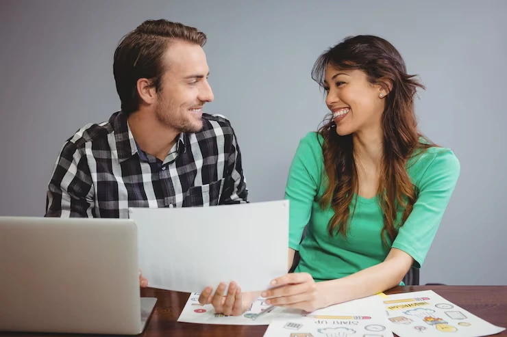 Copywriter and client reviewing email draft together with marketing materials on desk