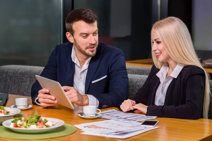 Sales professional presenting appointment metrics on tablet to client during business meeting