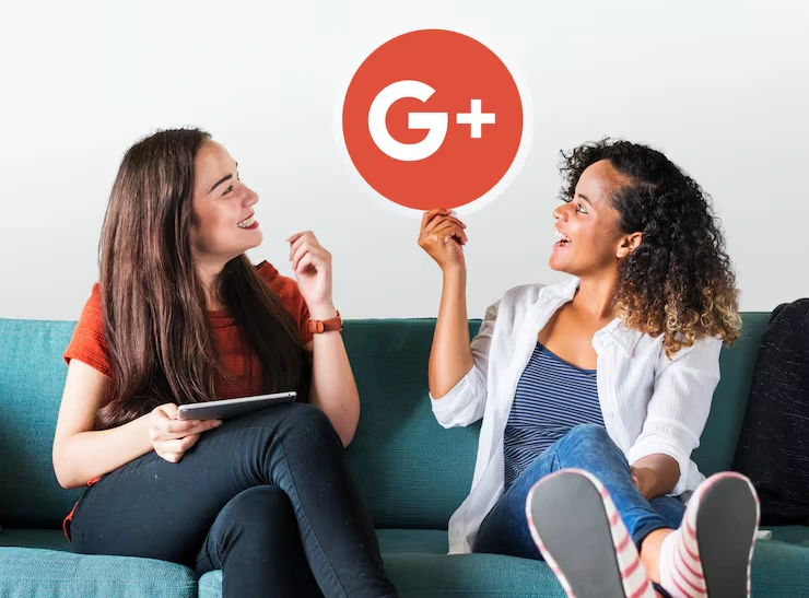 Two women discussing Google ratings strategy while holding G+ icon on couch